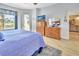 Bright bedroom featuring a large bed, dresser, and a doorway to another room at 4670 Links Village Dr # B102, Ponce Inlet, FL 32127