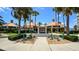 The front entrance to the clubhouse is framed by tall palm trees, leading to a well-maintained building with manicured landscaping at 4670 Links Village Dr # B102, Ponce Inlet, FL 32127