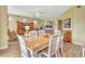 Dining room with wood table and chairs adjacent to the living room with lots of natural light at 4670 Links Village Dr # B102, Ponce Inlet, FL 32127