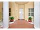 Well-kept entrance with columns, white door, and lush potted plants at 4670 Links Village Dr # B102, Ponce Inlet, FL 32127