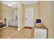 Inviting entryway with wood-look floors, neutral walls, and white trim and a view into a seating area at 4670 Links Village Dr # B102, Ponce Inlet, FL 32127