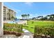 Picturesque view of the golf course from the building, showcasing manicured greens and palm trees at 4670 Links Village Dr # B102, Ponce Inlet, FL 32127