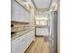 Bright kitchen featuring white cabinetry, granite countertops, stainless steel appliances, and wood-look flooring at 4670 Links Village Dr # B102, Ponce Inlet, FL 32127