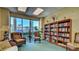Comfortable library area featuring a large bookshelf and views of the outdoors at 4670 Links Village Dr # B102, Ponce Inlet, FL 32127
