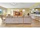 Expansive living room featuring a large sectional sofa, wood floors, and an open layout to the kitchen at 4670 Links Village Dr # B102, Ponce Inlet, FL 32127