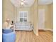 Bright living room with neutral tones, a large window, and wood look flooring at 4670 Links Village Dr # B102, Ponce Inlet, FL 32127