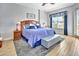 A main bedroom with a large bed, grey rug, wood flooring, and natural light streaming through the window, creating a calming atmosphere at 4670 Links Village Dr # B102, Ponce Inlet, FL 32127