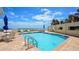 A relaxing outdoor pool area with lounge chairs, umbrellas, and a blue sky backdrop, offering a perfect setting for leisure at 4670 Links Village Dr # B102, Ponce Inlet, FL 32127