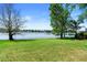 A serene backyard view with lush green lawn and a tranquil lake under a blue sky at 508 Quail Lake Dr, Debary, FL 32713