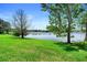 Beautiful backyard with green grass, mature trees, and a tranquil lake creating a peaceful setting at 508 Quail Lake Dr, Debary, FL 32713