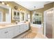 Bright bathroom featuring a double vanity, soaking tub with a view, and a glass-enclosed shower at 508 Quail Lake Dr, Debary, FL 32713