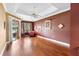 Bedroom featuring tray ceilings, hardwood floors, and sliding glass doors at 508 Quail Lake Dr, Debary, FL 32713