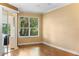 This bedroom features hardwood floors, a large window, and a door to a screened-in porch at 508 Quail Lake Dr, Debary, FL 32713