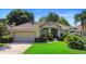 Well-maintained single-story home with a two-car garage, manicured lawn, and lush landscaping at 508 Quail Lake Dr, Debary, FL 32713