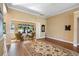 Spacious living room with hardwood floors, decorative rug, and a sunroom with a scenic view at 508 Quail Lake Dr, Debary, FL 32713