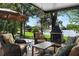 Inviting covered patio with comfortable seating, outdoor fireplace, and views of the lake at 508 Quail Lake Dr, Debary, FL 32713
