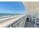 Balcony view overlooking the ocean, complete with comfortable seating arrangements for serene relaxation at 5207 S Atlantic Ave # 723, New Smyrna Beach, FL 32169