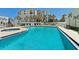 Outdoor pool area with ample seating surrounded by palm trees and overlooking nearby buildings at 5207 S Atlantic Ave # 723, New Smyrna Beach, FL 32169