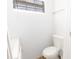 Bright bathroom features a white toilet, vanity, and a window for natural light at 5261 3Rd St, Orlando, FL 32810
