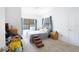Bedroom featuring a comfy bed, bright window with curtains, and convenient pet steps at 5261 3Rd St, Orlando, FL 32810