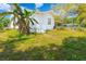 Exterior showcasing the white house, green grass, and landscape with small porch and stair entry at 5261 3Rd St, Orlando, FL 32810