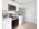Modern kitchen with stainless steel appliances, bright white cabinets, and a door to outside at 5261 3Rd St, Orlando, FL 32810