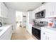 Stylish kitchen with stainless steel appliances and bright white cabinets, open to other rooms at 5261 3Rd St, Orlando, FL 32810