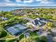 Aerial view showcasing the community amenities with tennis courts, a pool, and the clubhouse at 5305 Indian Ocean Loop, Tavares, FL 32778