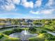 Scenic aerial view of the community clubhouse, pond with fountain, and manicured green spaces at 5305 Indian Ocean Loop, Tavares, FL 32778