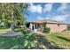 Beautiful backyard with manicured lawn, mature trees, and a patio with outdoor grill and seating at 5305 Indian Ocean Loop, Tavares, FL 32778