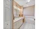 Bright bathroom with dual sinks, soaking tub, white cabinets, and ample lighting at 5305 Indian Ocean Loop, Tavares, FL 32778