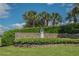 Community entrance sign with decorative plants, flowers, and palm trees at 5305 Indian Ocean Loop, Tavares, FL 32778