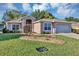 Charming single-story home with a well-manicured lawn and rock garden at 5305 Indian Ocean Loop, Tavares, FL 32778