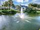 Scenic pond with a water fountain surrounded by lush landscaping and community buildings at 5305 Indian Ocean Loop, Tavares, FL 32778