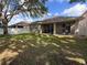 Spacious back yard featuring a covered patio and lush green lawn, perfect for outdoor living at 5548 Burlwood Dr, Orlando, FL 32810