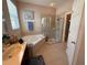 Bright bathroom features a soaking tub, glass enclosed shower, and double sink vanity at 5548 Burlwood Dr, Orlando, FL 32810
