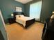 Bedroom with green accent walls, carpet flooring and a large window at 5548 Burlwood Dr, Orlando, FL 32810