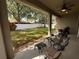 Relaxing covered patio with comfortable seating overlooking the well-maintained and spacious backyard with privacy fence at 5548 Burlwood Dr, Orlando, FL 32810