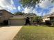 Charming single-story home with a well-manicured lawn, two-car garage and mature landscaping at 5548 Burlwood Dr, Orlando, FL 32810