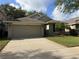 Lovely single-story home with a two-car garage, neat lawn, and a nicely paved driveway at 5548 Burlwood Dr, Orlando, FL 32810