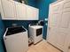 Well-lit laundry room with modern washer and dryer, ample storage, and a clean, functional space at 5548 Burlwood Dr, Orlando, FL 32810