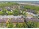 Aerial view of residences and a pond in a community with lush trees at 6078 Tivoli Gardens Blvd, Orlando, FL 32829