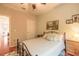 Cozy bedroom with a metal-framed bed, ceiling fan, and window view, creating a comfortable and inviting space at 6078 Tivoli Gardens Blvd, Orlando, FL 32829