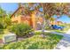 Two-story townhome displaying vibrant colors, a two-car garage, and mature landscaping, adding curb appeal at 6078 Tivoli Gardens Blvd, Orlando, FL 32829