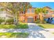 Two-story townhome featuring well-kept landscaping, a two-car garage, and an inviting orange and brown color scheme at 6078 Tivoli Gardens Blvd, Orlando, FL 32829