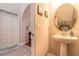 Half bathroom featuring a pedestal sink, mirror, and view of the entryway and stairs at 6078 Tivoli Gardens Blvd, Orlando, FL 32829