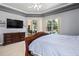 Primary bedroom includes a TV, dresser, and a view of the pool area at 6111 Oxbow Bend Ln, Port Orange, FL 32128
