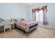 Bedroom with colorful bedding, white wicker furniture, and bright natural light at 6111 Oxbow Bend Ln, Port Orange, FL 32128