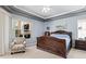 Primary bedroom with an ornate wood bed, large windows, and tray ceiling at 6111 Oxbow Bend Ln, Port Orange, FL 32128