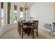 Bright dining room featuring a chandelier, large windows, and a round table with six chairs at 6111 Oxbow Bend Ln, Port Orange, FL 32128